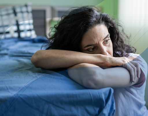 An exhausted looking person sat with their head in their arms.