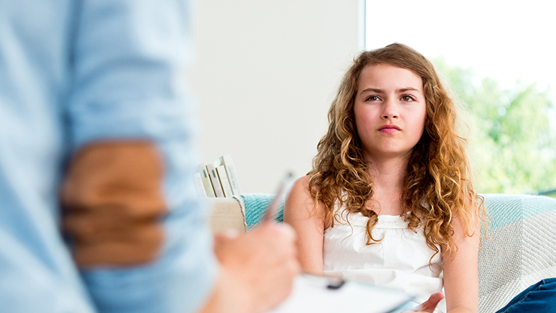 A young person in a room with a health professional.