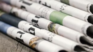 A pile of folded newspapers and journals